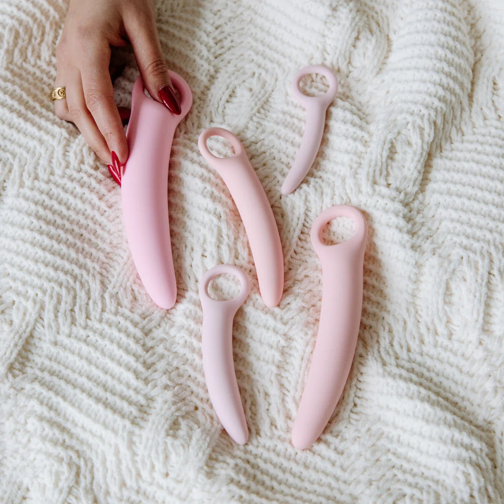 A pastel dilator set arranged on a knitted throw